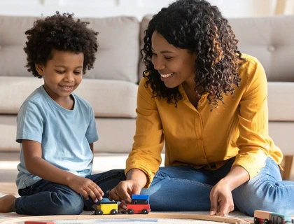 A therapist and a child playing with wooden toys